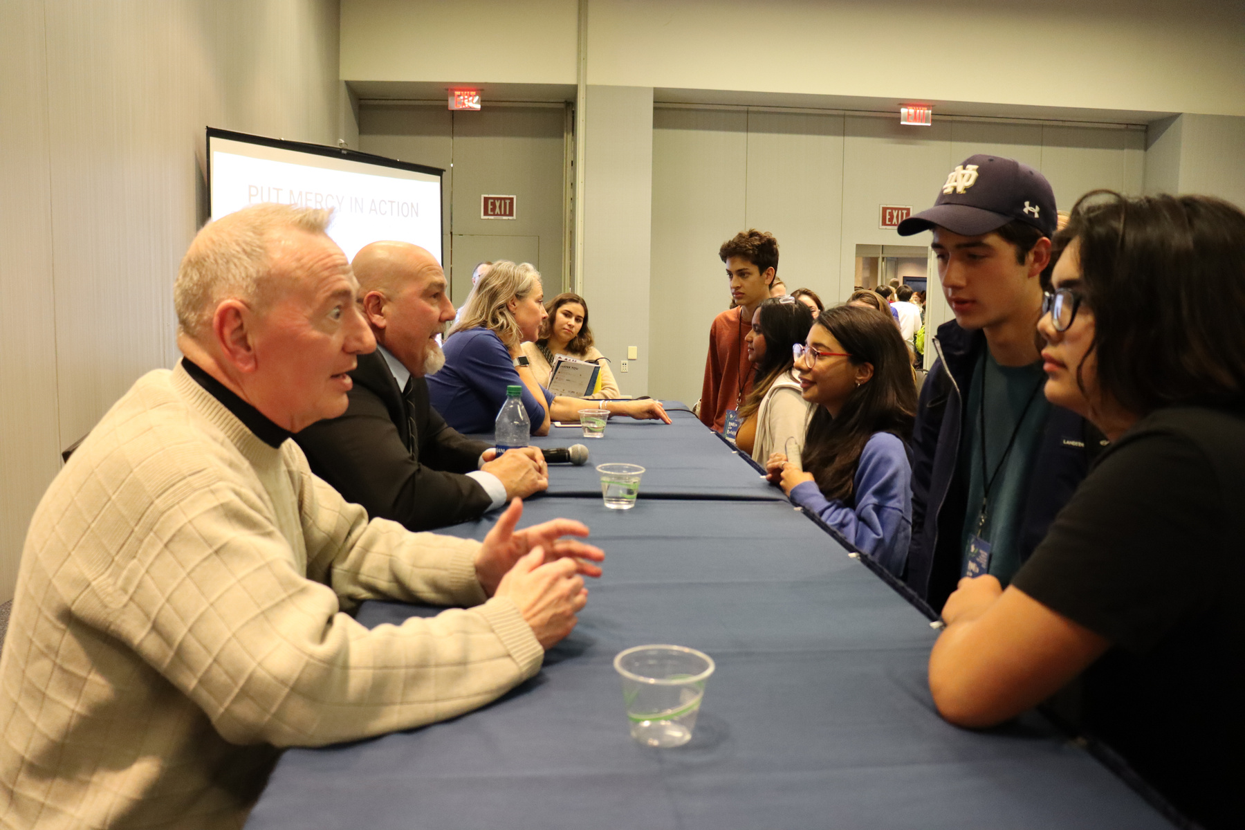 CMN presenters speak across a table with young people at IFTJ